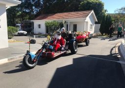 Papai Noel chega de triciclo no Recanto dos Velhinhos levando muitas doações